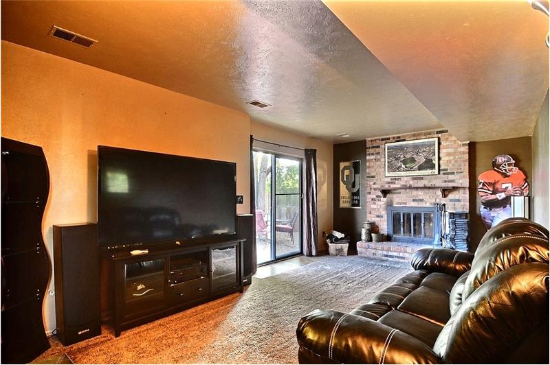 Family Room with Wood-Burning Fireplace & Door to Patio