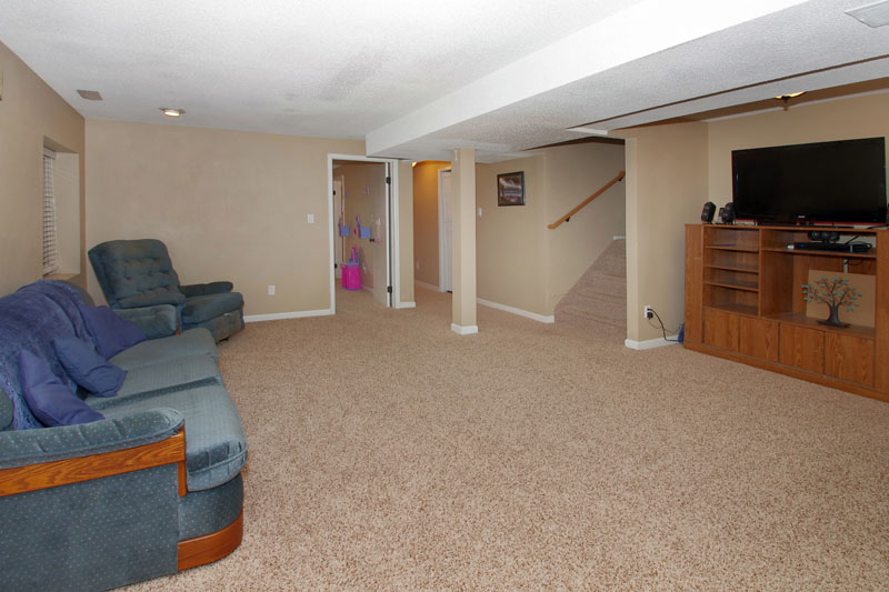 Family room in basement with recessed lighting.  