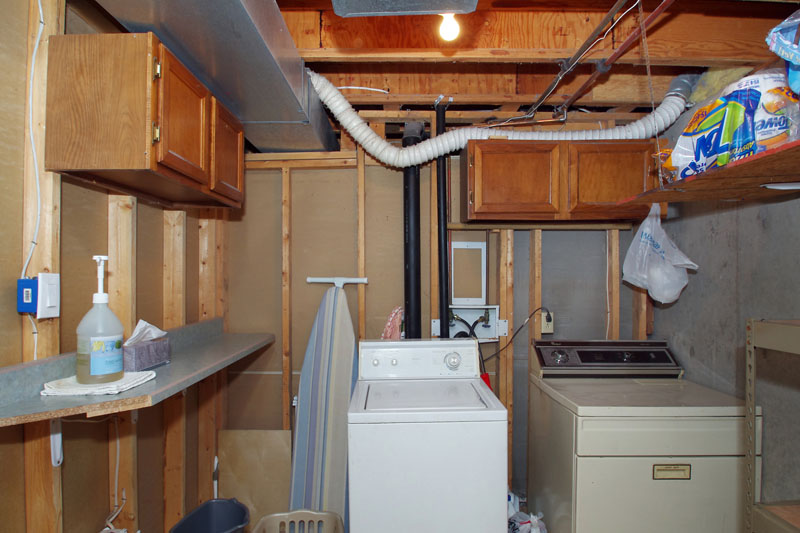 Nice laundry area with tile flooring, cabinets, and built in countertop