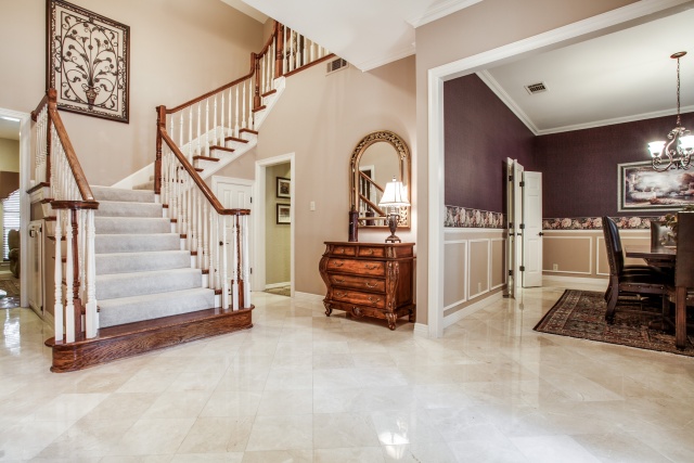 The large foyer with marble floors leads to a beautiful dining room.