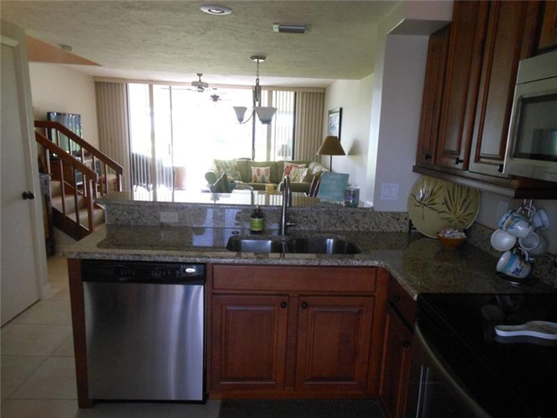 Kitchen looking out to dining/living areas and silders to tiled lanai