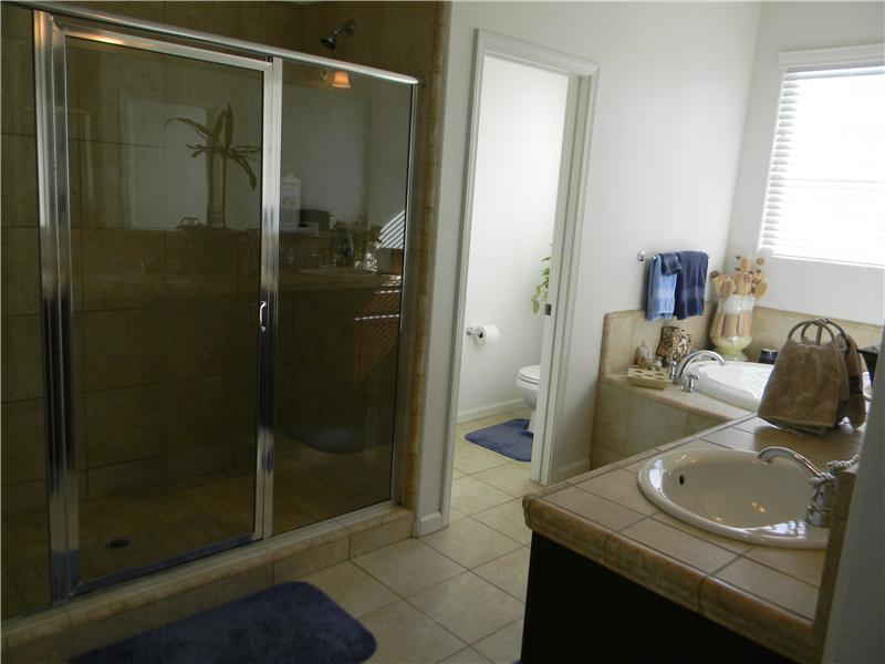 The shower stall has two shower heads, one on each side