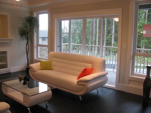 Living room with patio door leading to the front deck with view of greenbelt on the opposite side