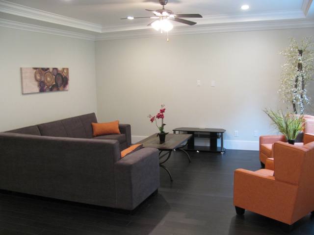 Family room with laminate floor, crown moulding and baseboard