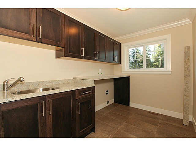 Laundry room with granite counter and cabinets
