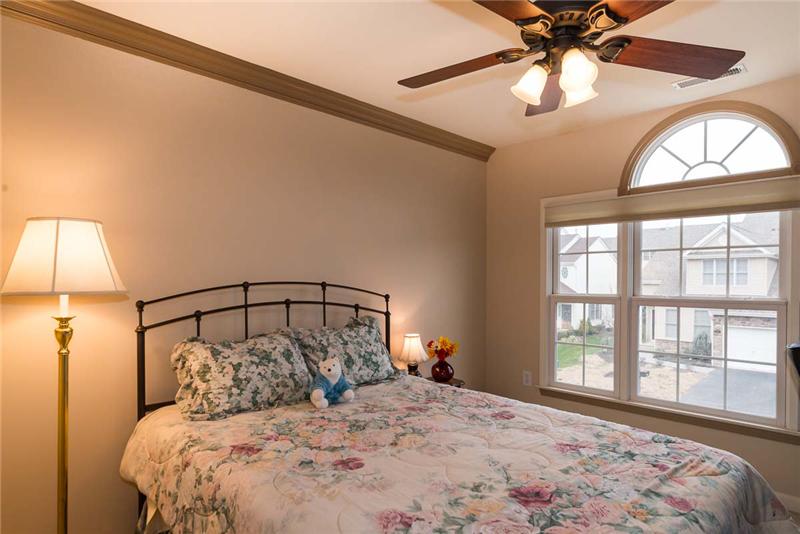 Third bedroom with lovely arched window and lighted ceiling fan.