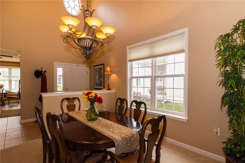View of the dining room and foyer with kitchen entrance on left.