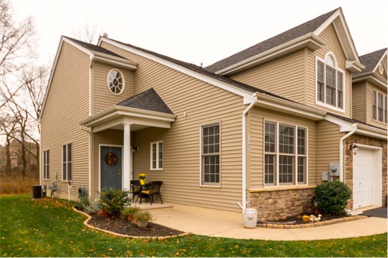 Charming rounded sidewalk leads to front porch sitting area.