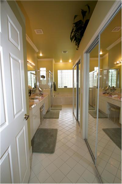 master bath with dual sinks and walk in closets